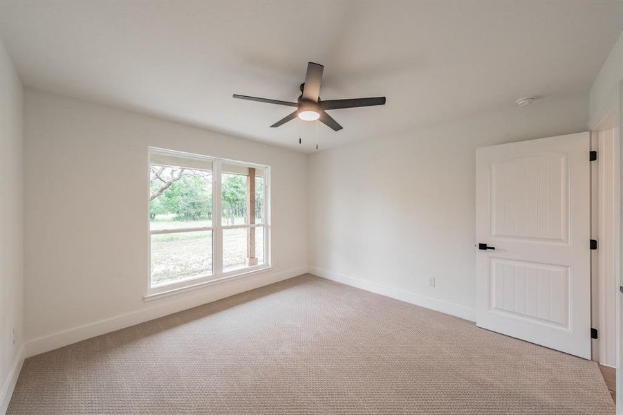 Empty room with carpet flooring, a ceiling fan, and baseboards