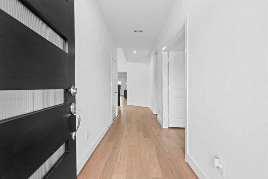 Step inside through the modern front door into a bright, inviting hallway with warm woodlike vinyl flooring, clean white walls, and recessed lighting. This airy entry provides a perfect transition into the heart of the home. **Image Representative of Plan Only and May Vary as Built**. Step inside through the modern front door into a bright, inviting hallway with warm woodlike vinyl flooring, clean white walls, and recessed lighting. This airy entry provides a perfect transition into the heart of the home. **Image Representative of Plan Only and May Vary as Built**.
