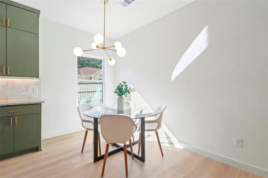 Dining area with light wood finished floors and a chandelier
