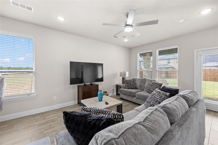 This bright and incredibly spacious family room serves as the heart of the home, featuring beautiful wood-look tile flooring and crisp neutral walls.