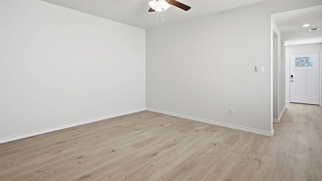Unfurnished room featuring light wood-type flooring and a ceiling fan