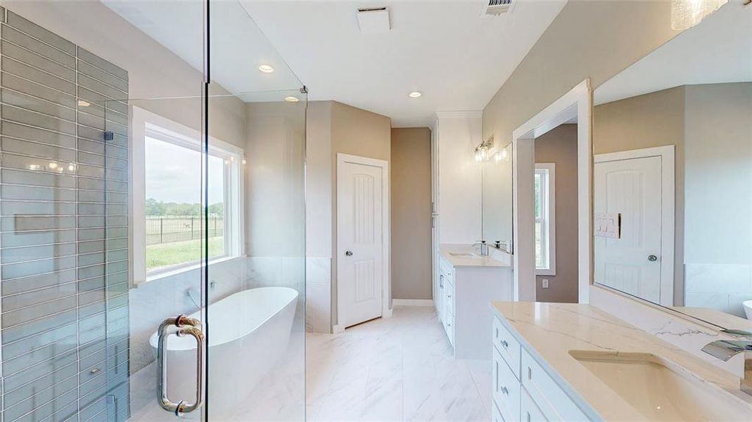 Separate vanities with quartz counters and a built-in linen closet