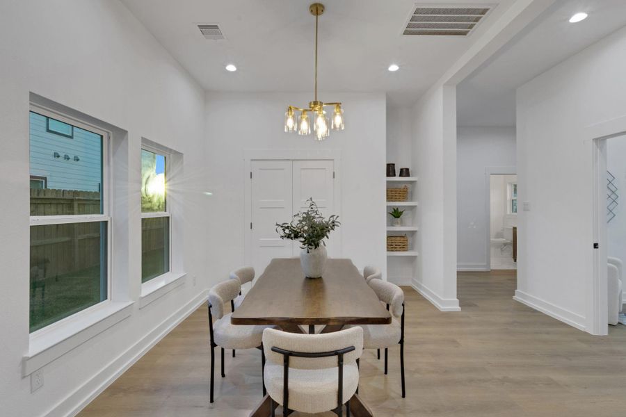 Bright dining space with large windows and an elegant chandelier, offering a welcoming setting for family meals and gatherings. Bright dining space with large windows and an elegant chandelier, offering a welcoming setting for family meals and gatherings.