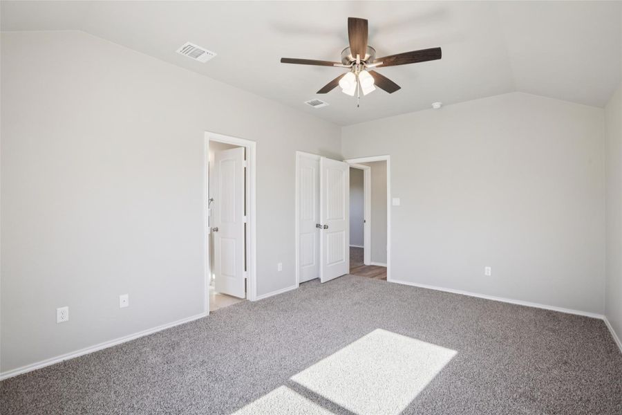 Unfurnished bedroom with light colored carpet and ceiling fan
