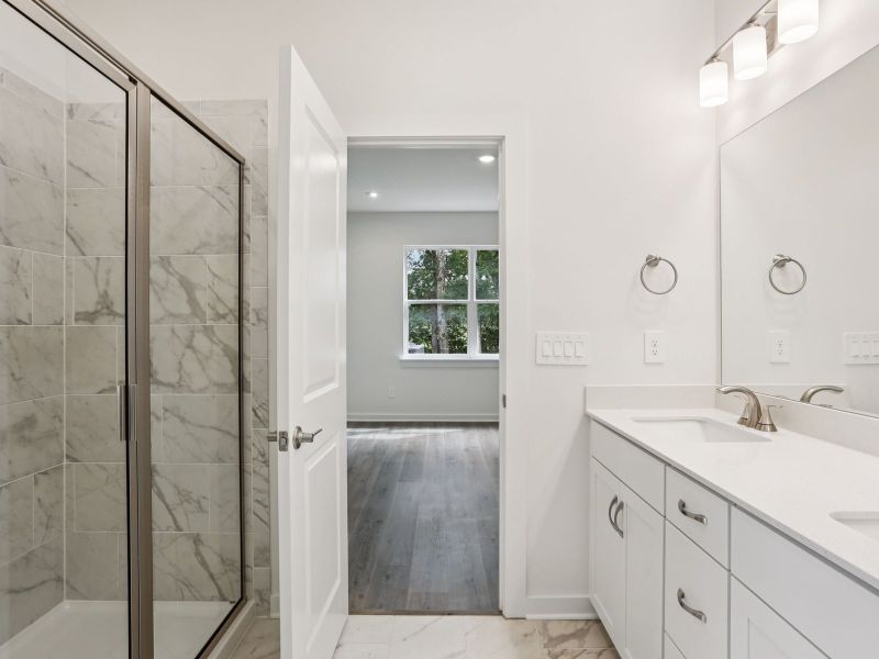 The primary bathroom offers dual vanity sinks and a walk-in shower.