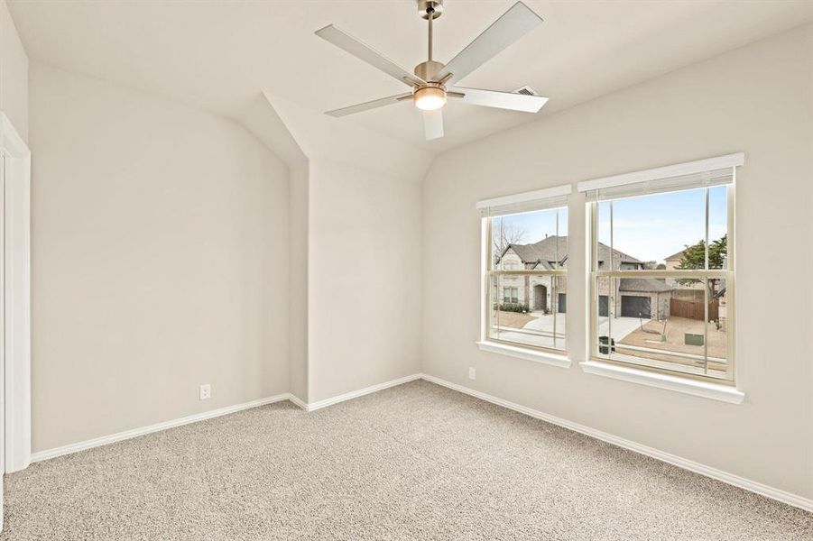 Carpeted spare room featuring a ceiling fan and lofted ceiling