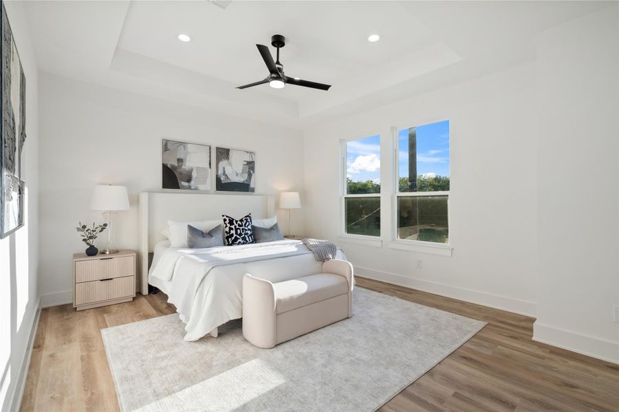 The primary suite is generously sized and features elegant recessed ceilings, adding depth and architectural interest. Its spacious layout provides a serene retreat for relaxation and rest. This luxurious design balances comfort with modern farmhouse charm