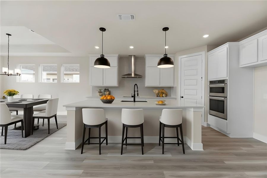 Kitchen featuring a kitchen bar, pendant lighting, a kitchen island with sink, white cabinetry, and recessed lighting