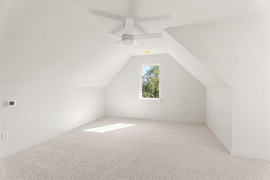 Bonus room featuring carpet flooring, lofted ceiling, and a ceiling fan