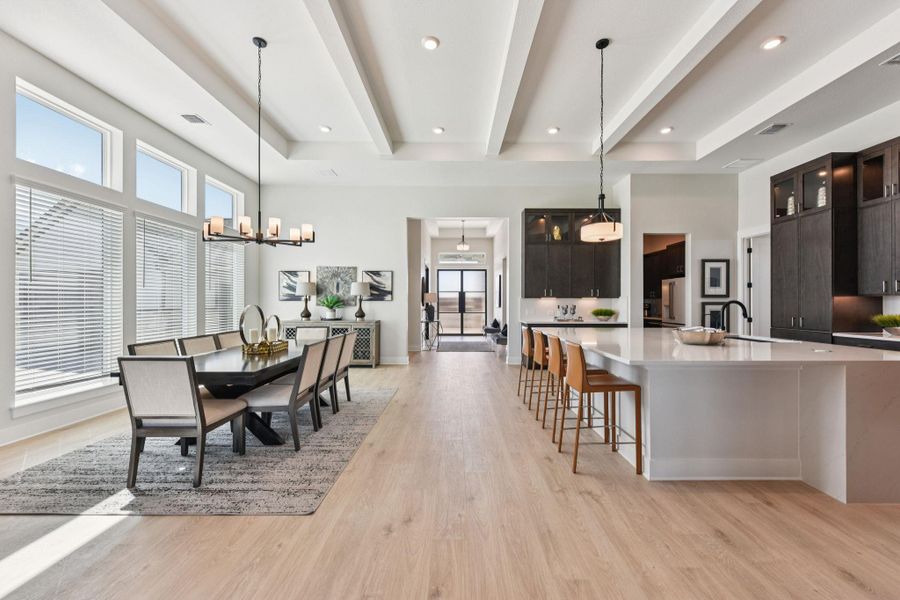 Dining space with light wood finished floors and hanging lights