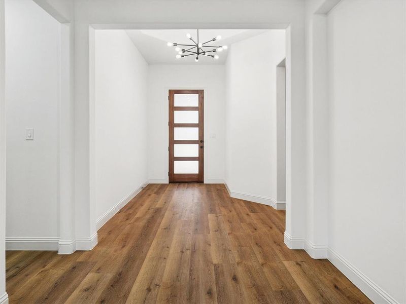 Doorway to outside featuring wood finished floors and suspended lighting
