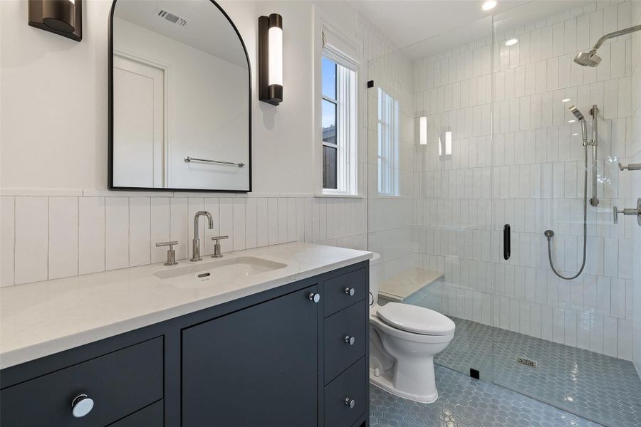 Bathroom with vanity, a stall shower, tile walls, and tile patterned floors Bathroom with vanity, a stall shower, tile walls, and tile patterned floors