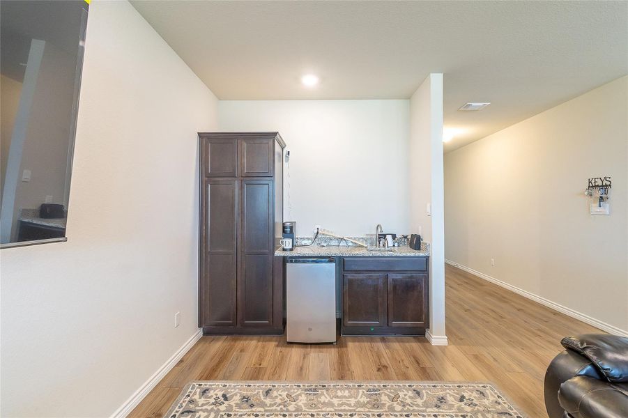 A well-appointed wet bar area, complete with sleek cabinetry and a mini-refrigerator, enhances this living space. A well-appointed wet bar area, complete with sleek cabinetry and a mini-refrigerator, enhances this living space.