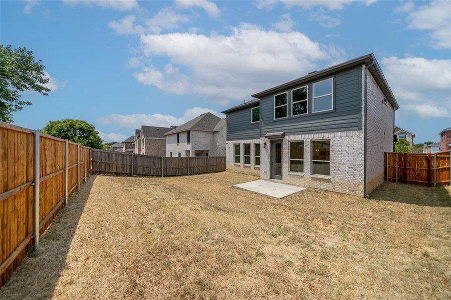 Back of property featuring a patio and a lawn