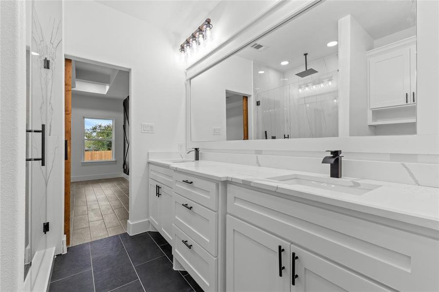 Bathroom featuring vanity, walk in shower, and tile patterned flooring