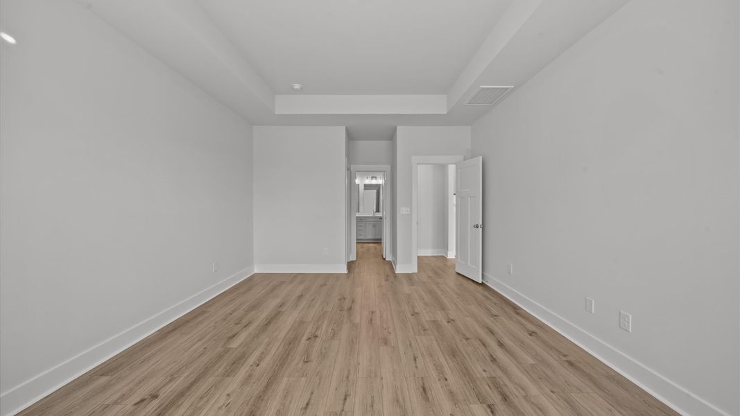 Accomplished primary retreat with eye-catching hardwood flooring in a desirable community