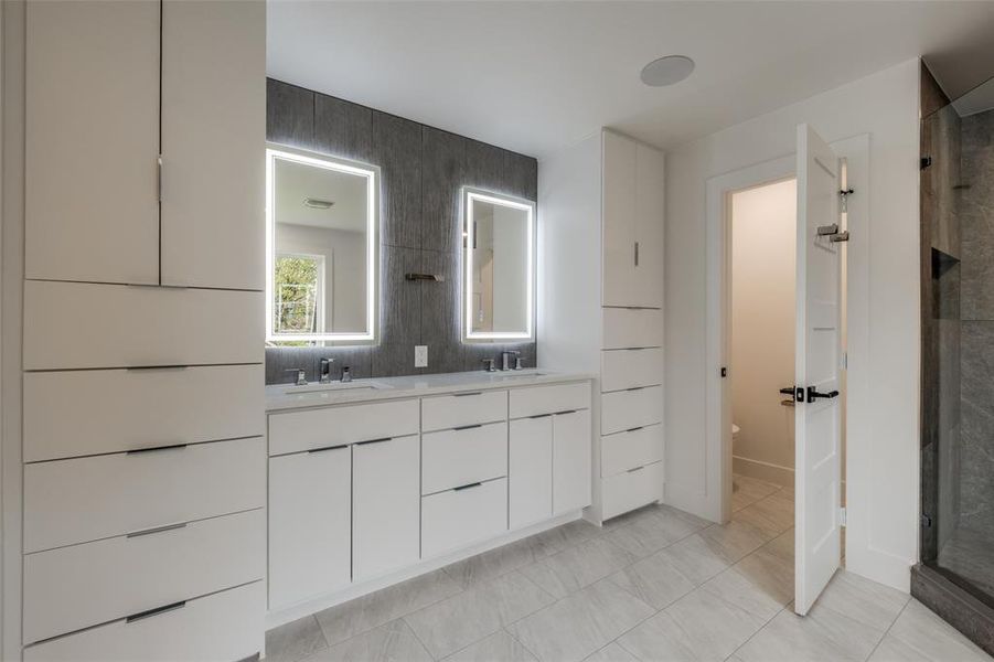 Full bathroom featuring double vanity, a shower stall, and tasteful backsplash