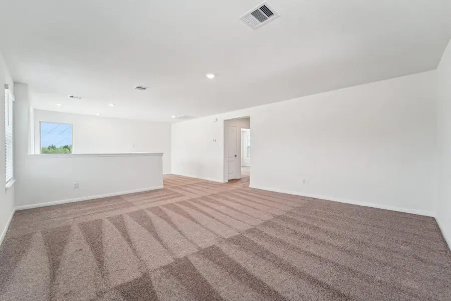 Another perspective of the Game Room, showcasing the staircase and hallway leading to the secondary bedrooms and bathroom.