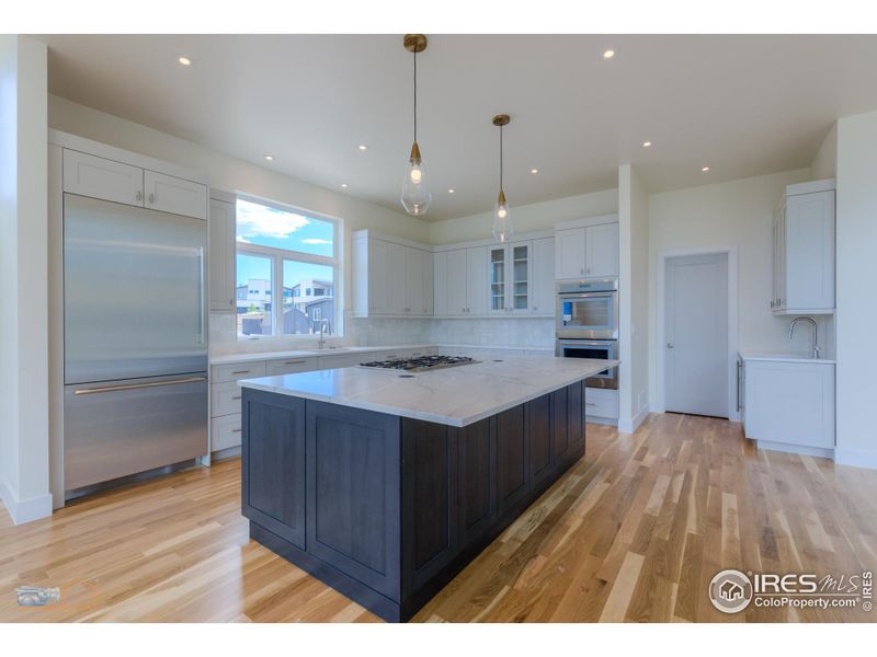 Spacious Kitchen Features A Large Island With A Quartzite Countertop, Thermador SS Appliances, Custom Cabinetry, Wet Bar And Pantry