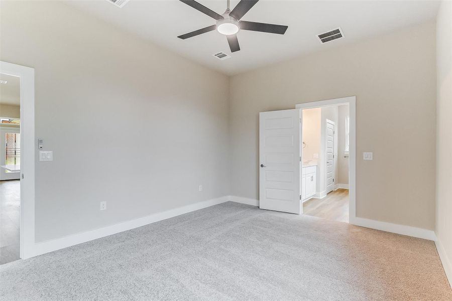 Spare room featuring a ceiling fan and light colored carpet