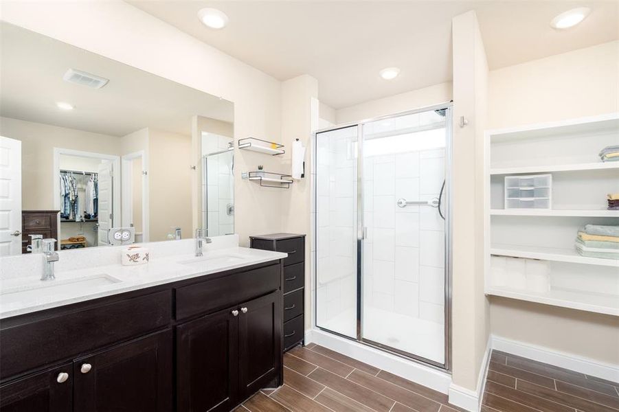 Large counter with double sinks, large open shelfs and a large shower. Also includes private toilet area and large walk in closet.