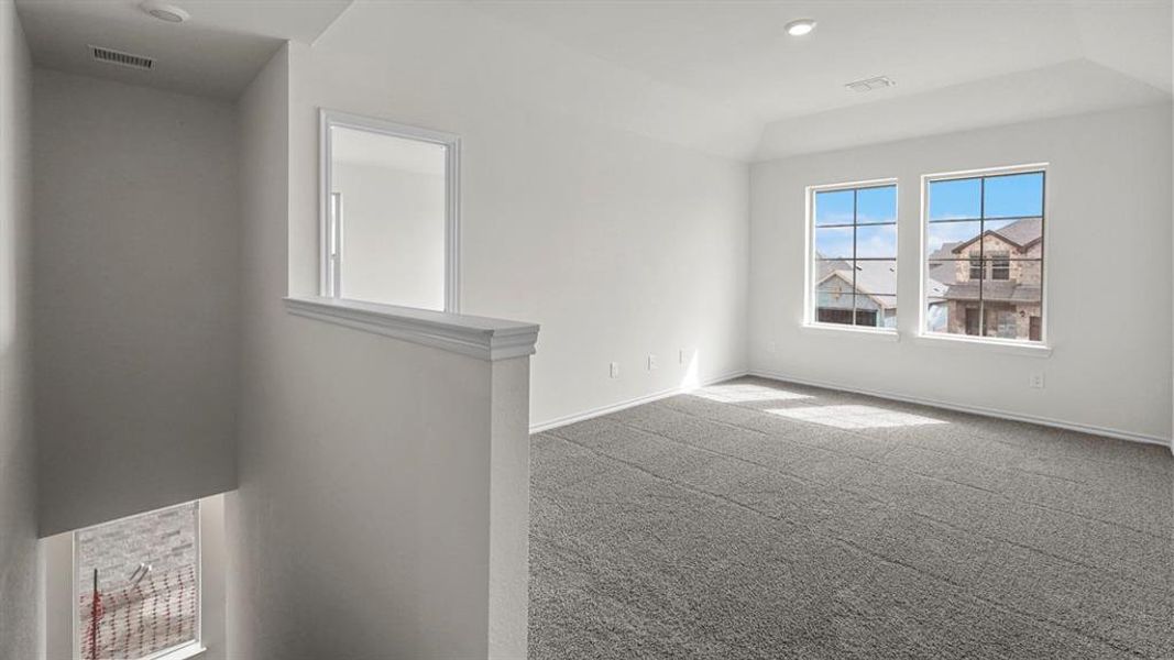 This versatile room features two windows and soft gray carpeting, offering abundant natural light