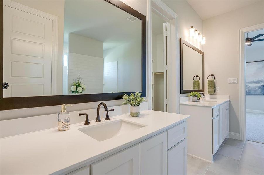 Bathroom featuring double vanity, tile patterned flooring, and ceiling fan