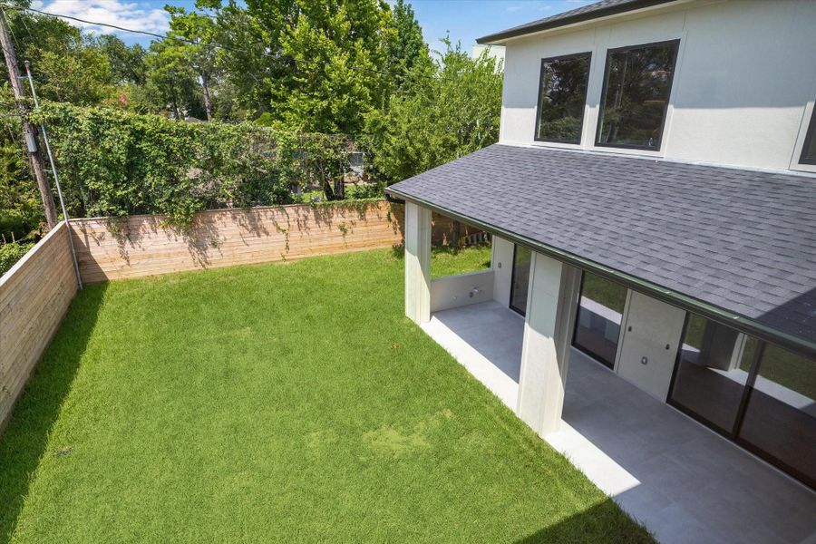 Aerial view of private fenced backyard with shaded patio. Aerial view of private fenced backyard with shaded patio.