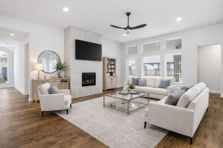 Virtually staged to help you envision the possibilities, this living room speaks for itself. The floor-to-ceiling tiled fireplace anchors the space with warmth and understated elegance. There is room for everyone here a house full of guests, or just a quiet evening by the fire. The furniture may be virtual however the feeling is very real.