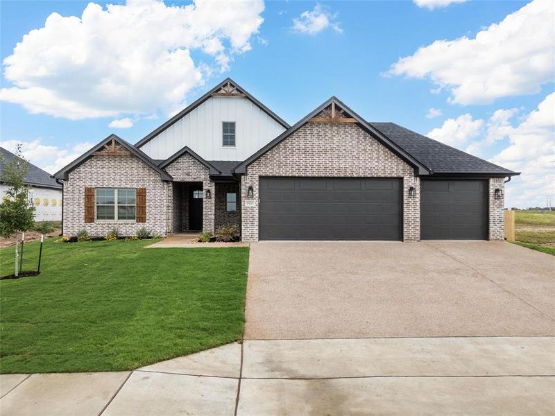 View of front facade featuring concrete driveway, an attached garage, board and batten siding, brick siding, and a front lawn View of front facade featuring concrete driveway, an attached garage, board and batten siding, brick siding, and a front lawn