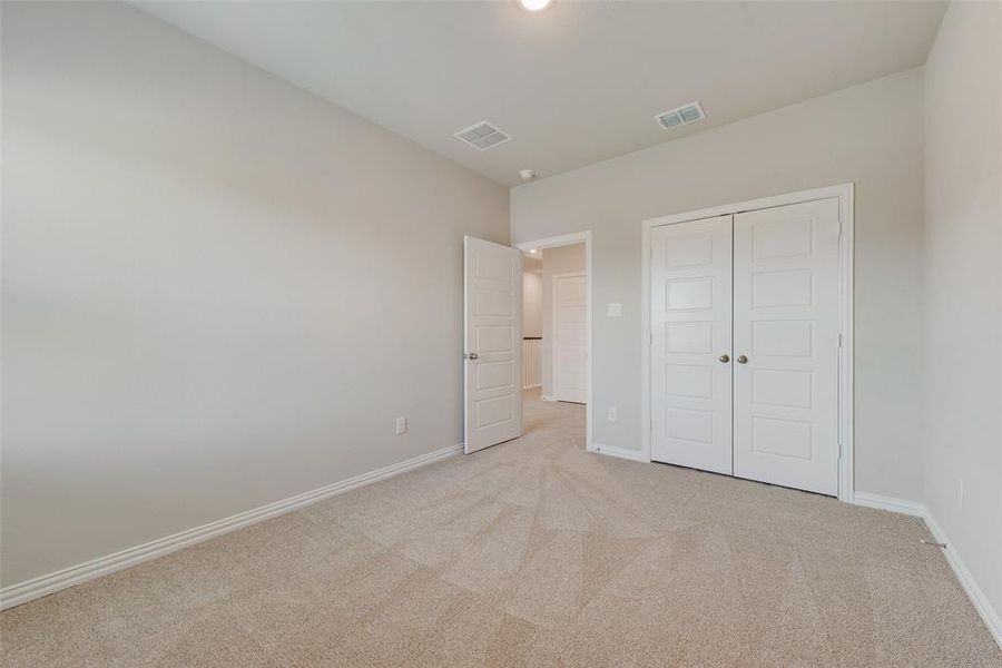 Unfurnished bedroom featuring light colored carpet and a closet