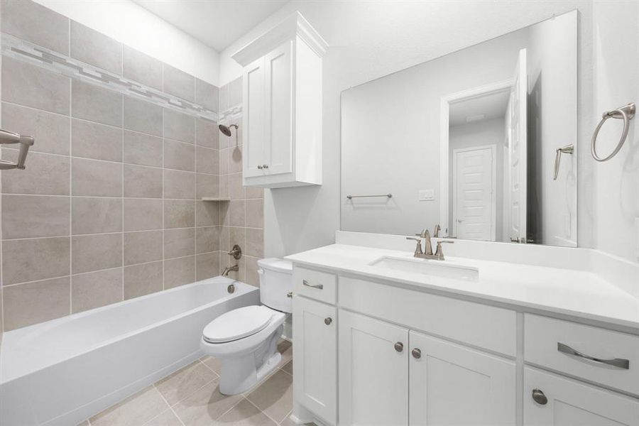 Secondary bathroom with vanity, bathtub / shower combination, and ceramic tile patterned flooring