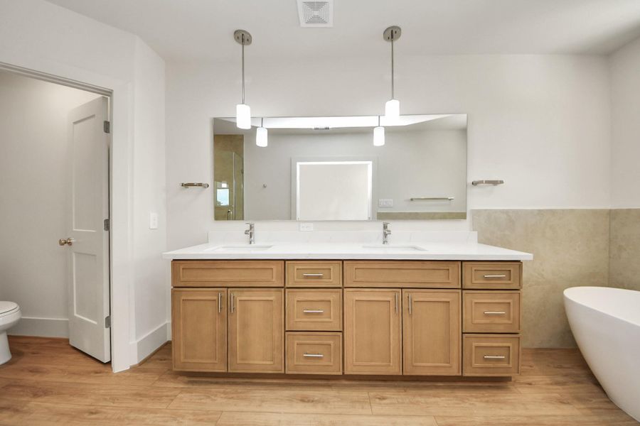 MB3 Floorplan – Primary BathroomThe spa-inspired primary bathroom features a double vanity with ample storage, sleek pendant lighting, and a soaking tub for ultimate relaxation.
