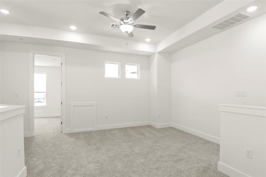 Empty room featuring ceiling fan, light carpet, and recessed lighting