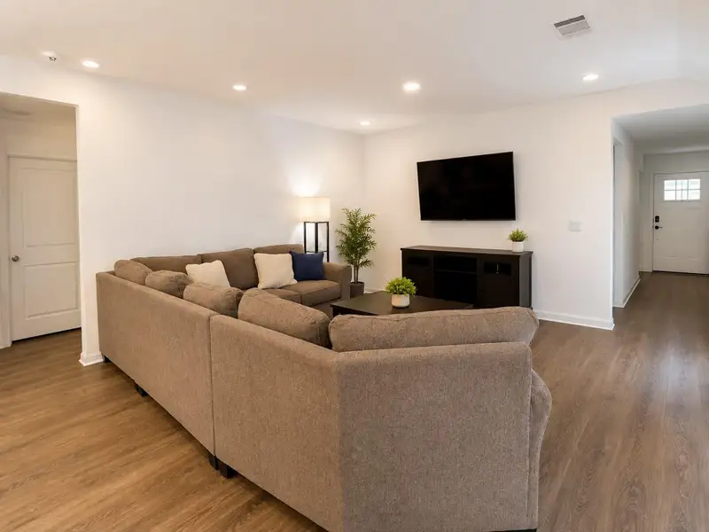 Recessed lighting illuminates a comfortable living space featuring rich LVP flooring and a front entry. Recessed lighting illuminates a comfortable living space featuring rich LVP flooring and a front entry.