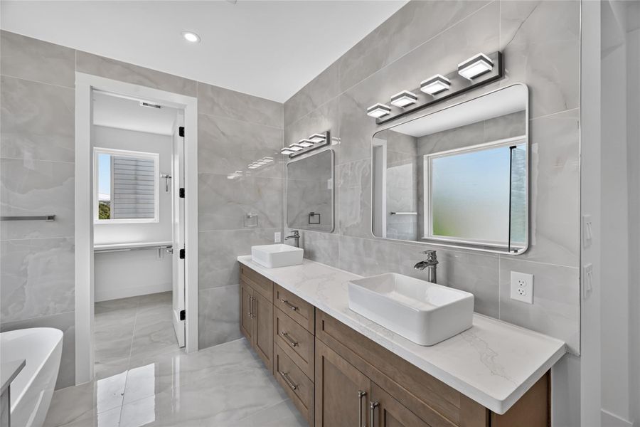 Beautiful custom cabinets with sleek sinks, brass nickel hardware and plenty of storage space.