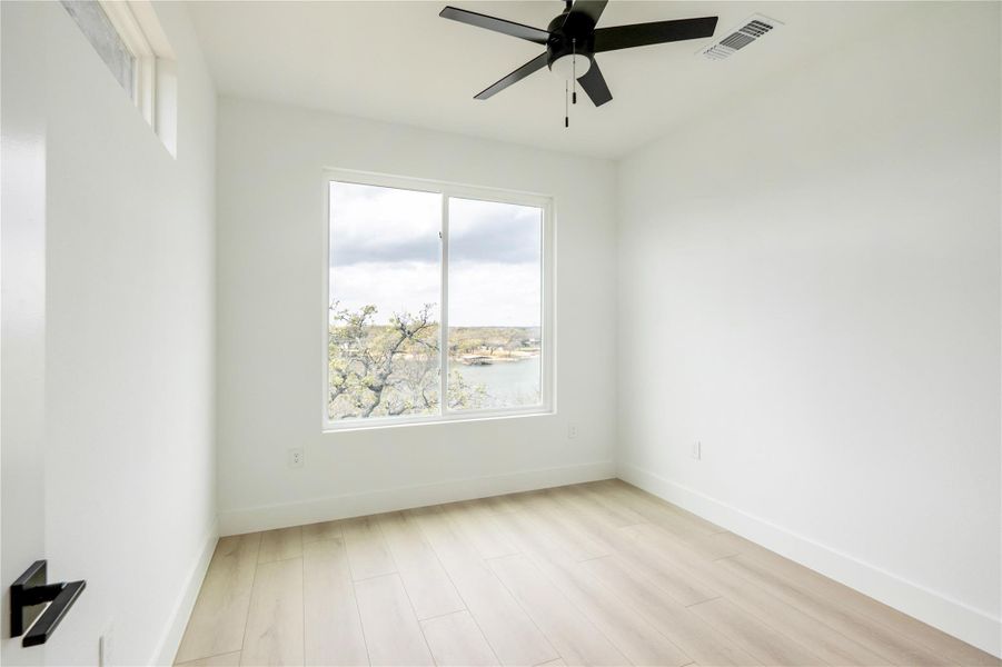 Empty room featuring ceiling fan and light wood finished floors