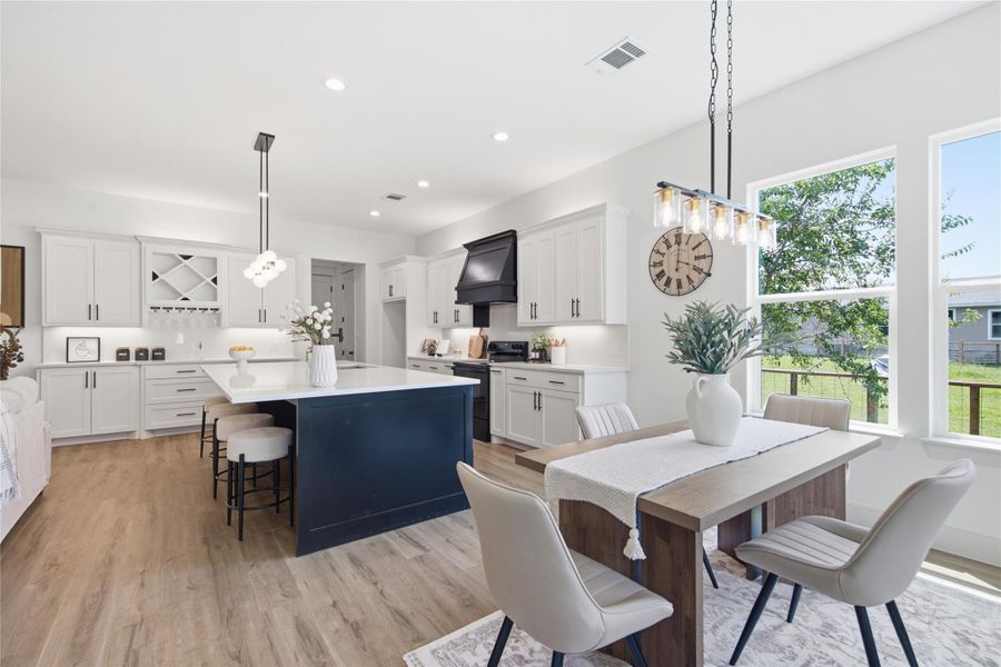 A contemporary kitchen and dining space, illuminated by abundant natural light, creates an inviting atmosphere for daily living. A contemporary kitchen and dining space, illuminated by abundant natural light, creates an inviting atmosphere for daily living.