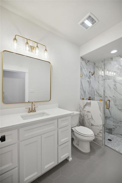 Bathroom with vanity, walk in shower, toilet, and tile patterned floors