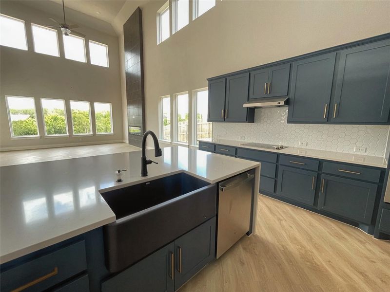 An open-concept living space integrates a contemporary kitchen with a grand two-story living area. An open-concept living space integrates a contemporary kitchen with a grand two-story living area.