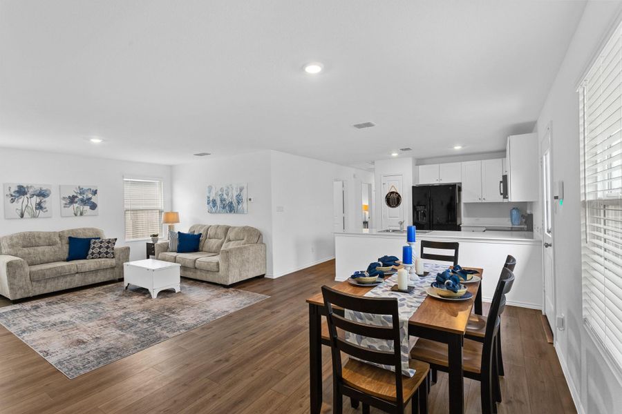 Open-concept living area featuring wood-finish flooring, recessed lighting, and white walls