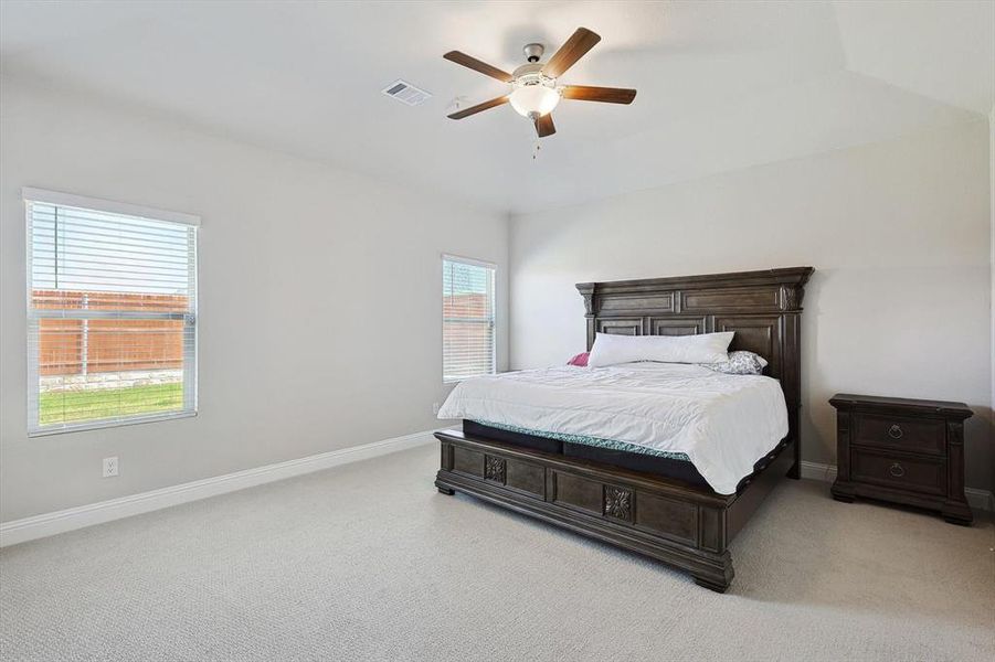 Bedroom featuring ceiling fan, vaulted ceiling, and light colored carpet