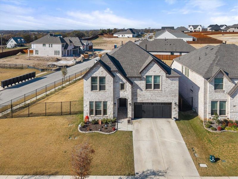 French country style house with driveway, stone siding, a residential view, and a garage