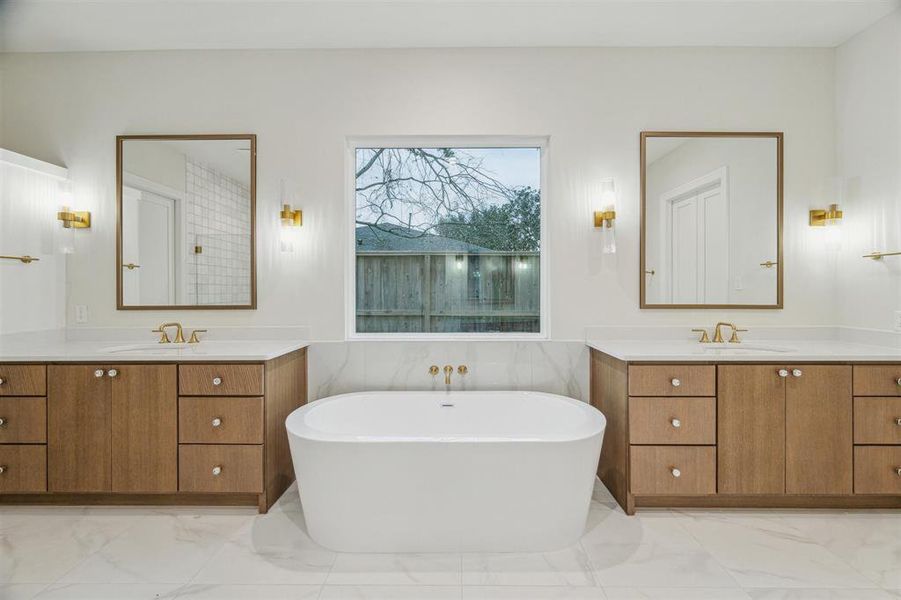 Soaking tub flanked by double vanities