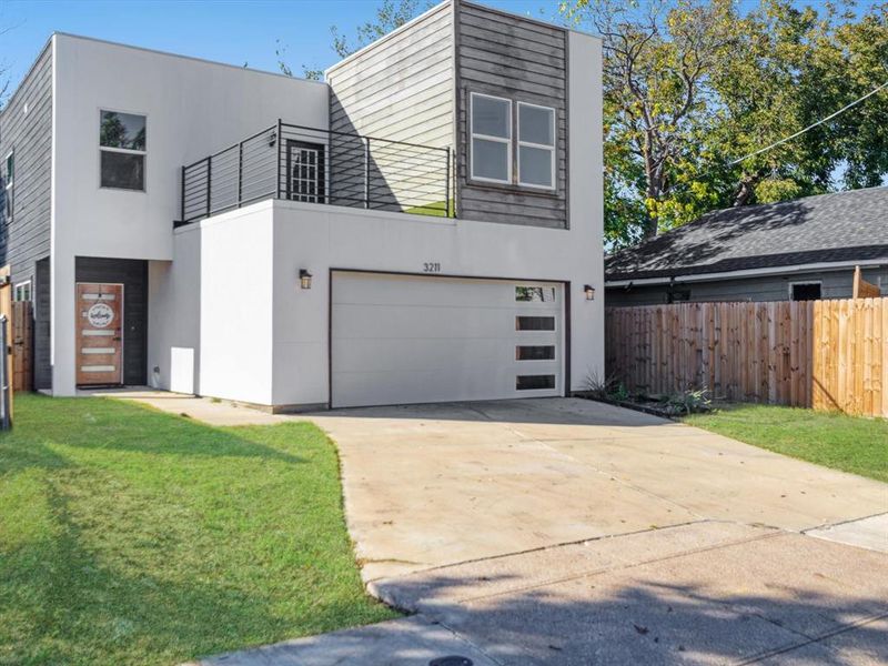 Contemporary home featuring a garage and a front lawn