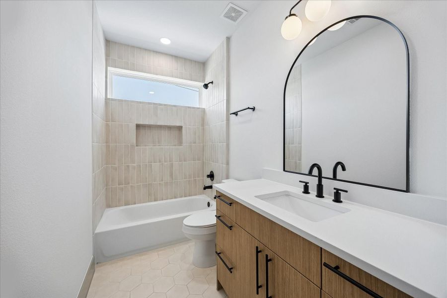 Clean, timeless finishes including matte black fixtures, quartz countertops, and full height tile create a polished guest bath. Clean, timeless finishes including matte black fixtures, quartz countertops, and full height tile create a polished guest bath.