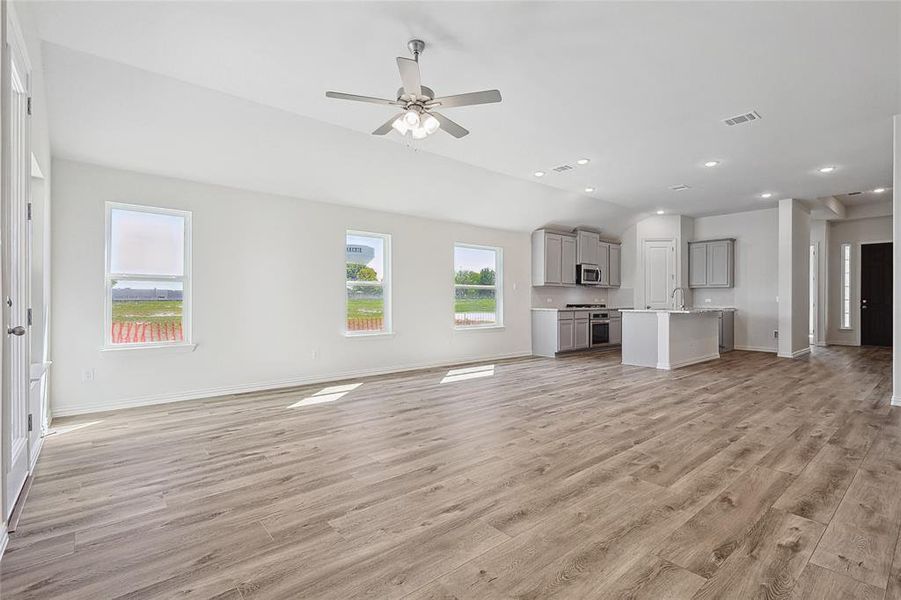 Unfurnished living room featuring light hardwood / wood-style floors, sink, and ceiling fan