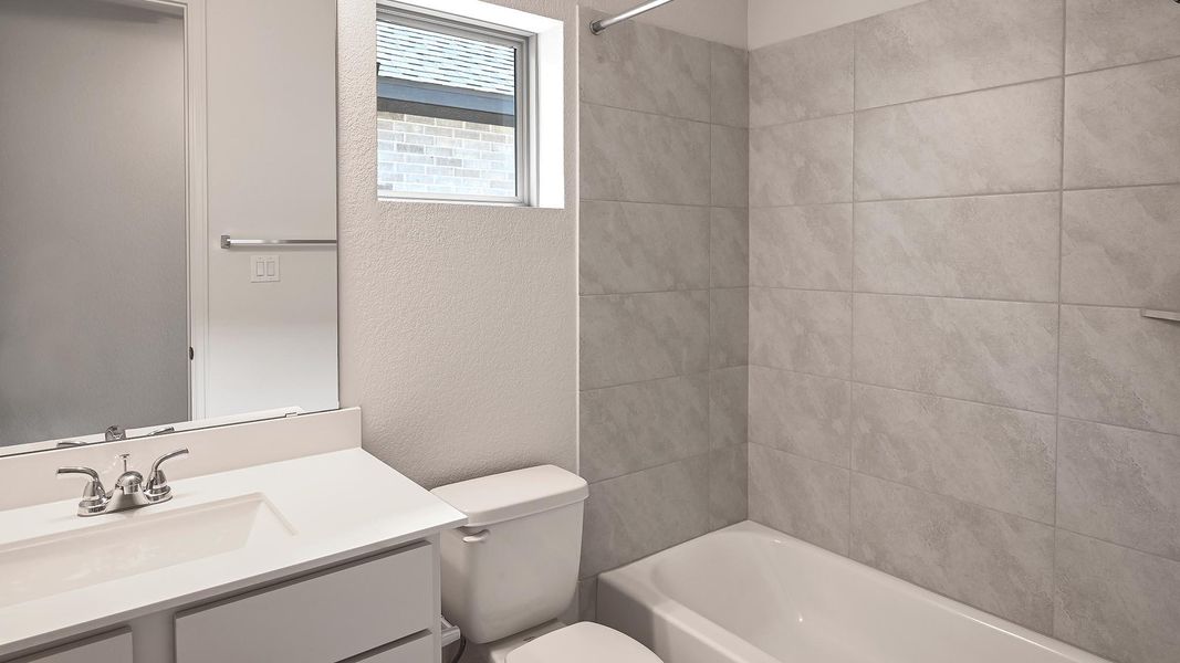 Bathroom with a textured wall, vanity, and shower / bath combination