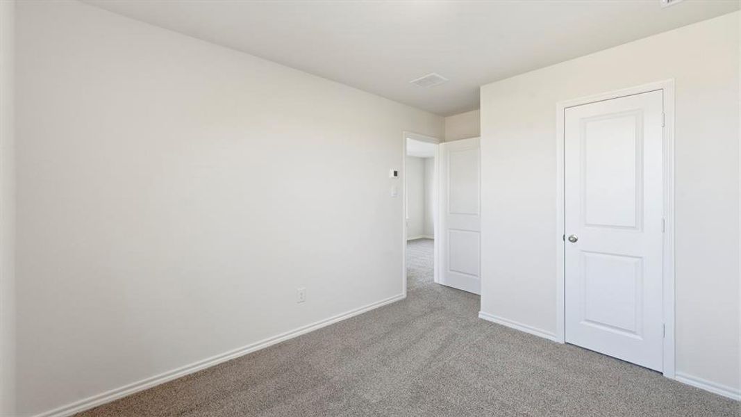 Unfurnished bedroom with carpet flooring and baseboards Unfurnished bedroom with carpet flooring and baseboards