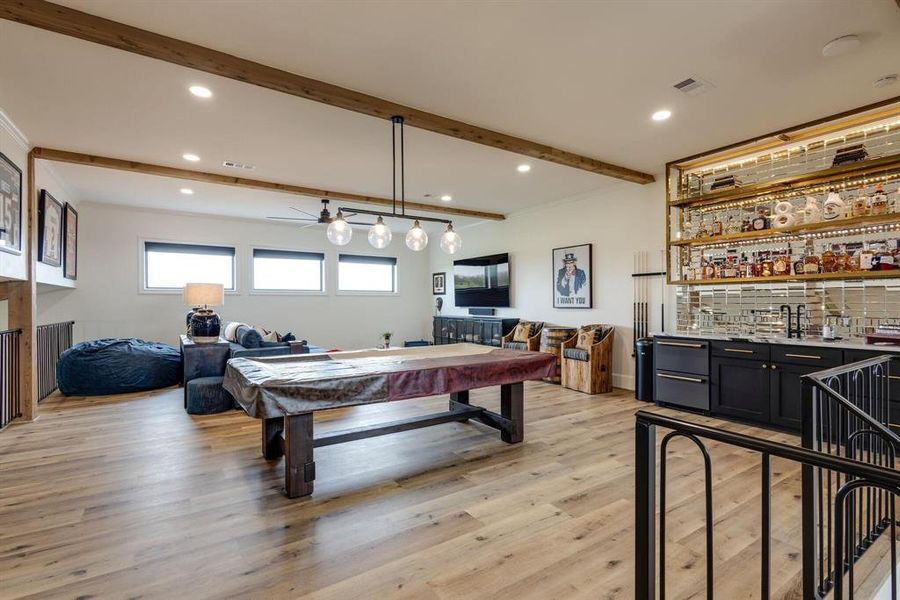 Rec room with ceiling fan, light hardwood / wood-style flooring, beamed ceiling, billiards, and indoor bar Rec room with ceiling fan, light hardwood / wood-style flooring, beamed ceiling, billiards, and indoor bar